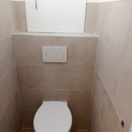 Sprchová batéria a vývody v sivom obklade kúpeľne