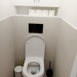 Závesné WC s čiernym ovládacím tlačidlom a hornou skrinkou